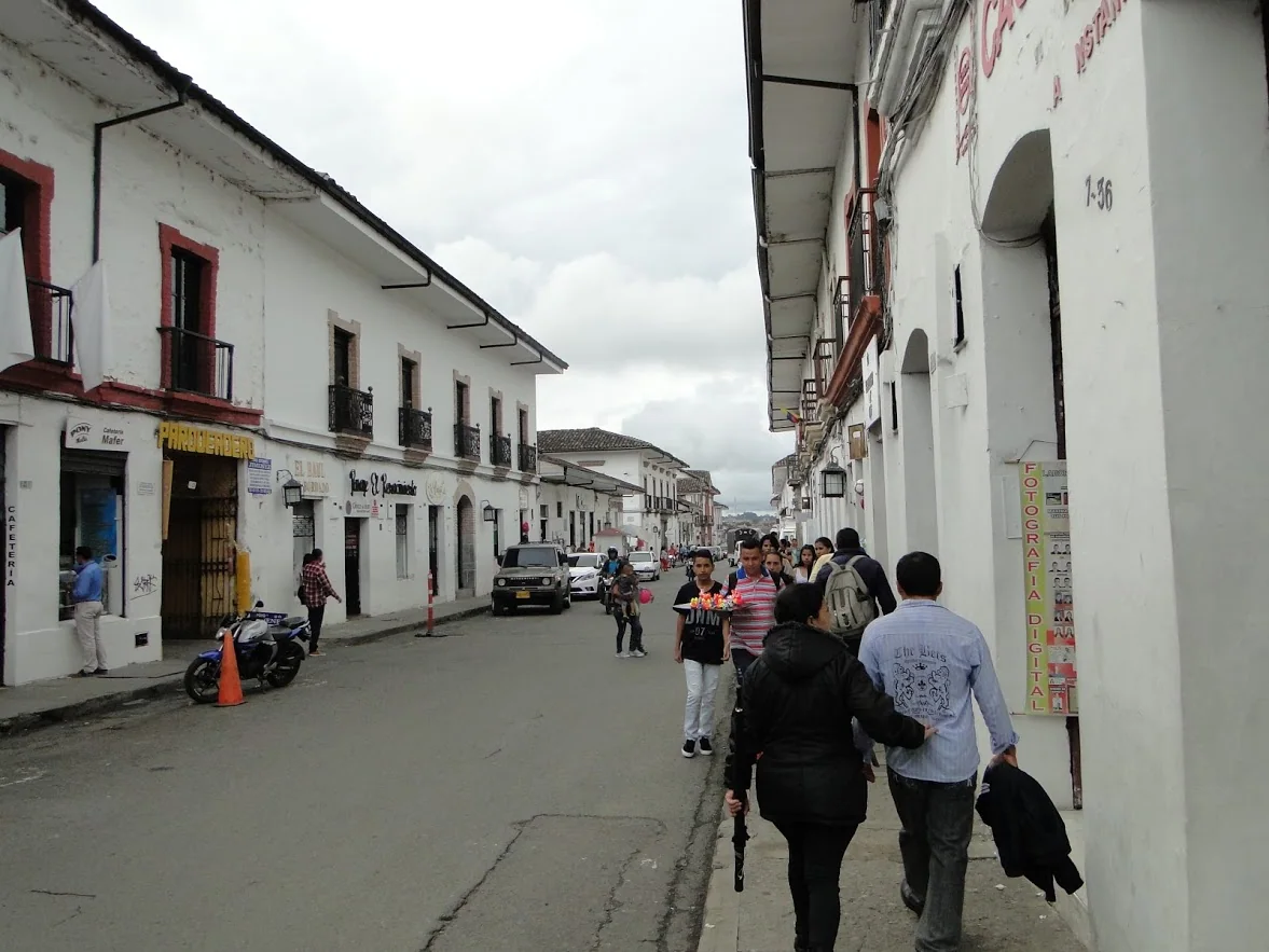 Personas caminando por una calle de Popayán, Cauca, entre edificios bajos; contexto regional de 2019.