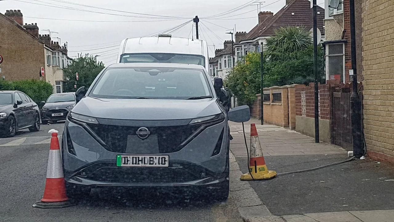 Historical Haringey photograph of a surface charging cable across a pavement, not an embedded channel.