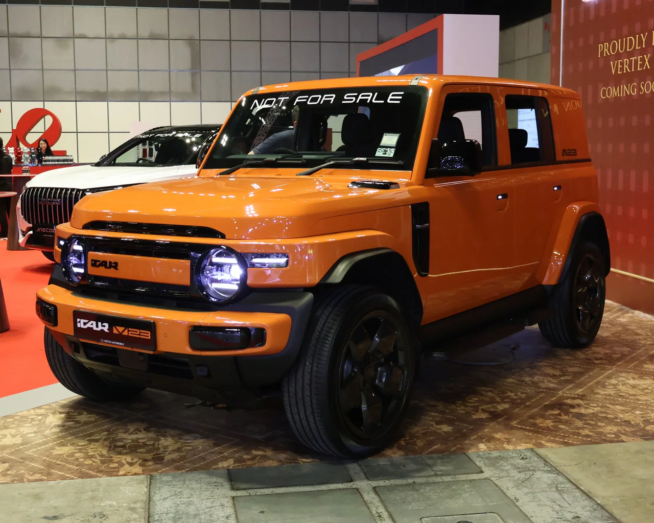 Orange iCAUR V23 showcar displayed at Singapore Motorshow 2026; a not-for-sale notice is visible on the windscreen.