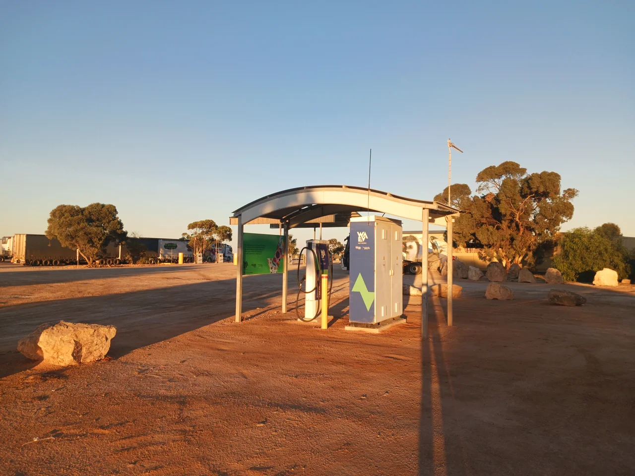 EV fast-charger equipment beneath a shelter at Mundrabilla Roadhouse in Western Australia, photographed 16 July 2026. The image is a local infrastructure example, not a roadmap project site.