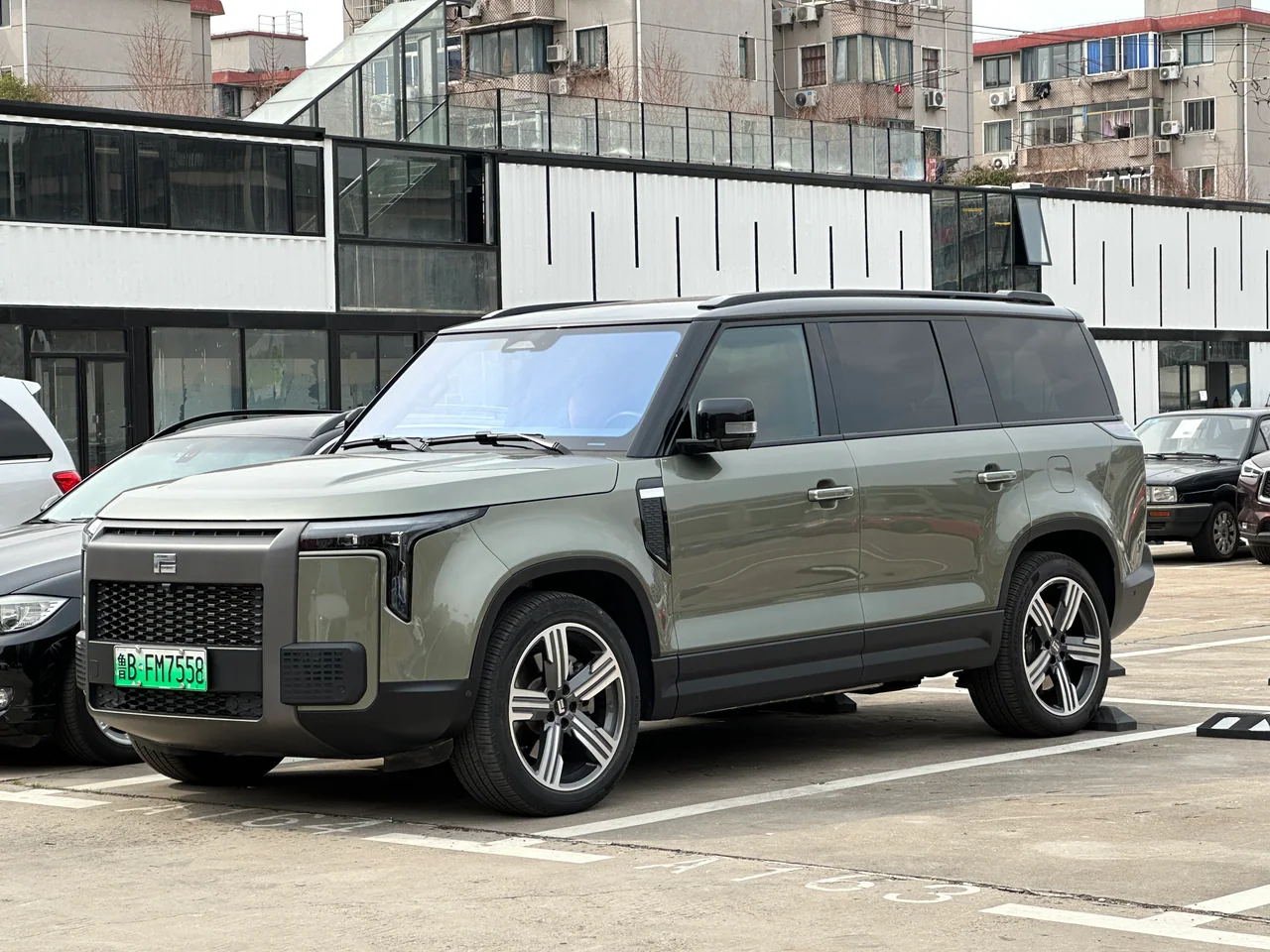 SUV ROX 01 gris verdoso, con una placa de formato chino visible, fotografiado en un estacionamiento urbano; el lugar no está identificado.